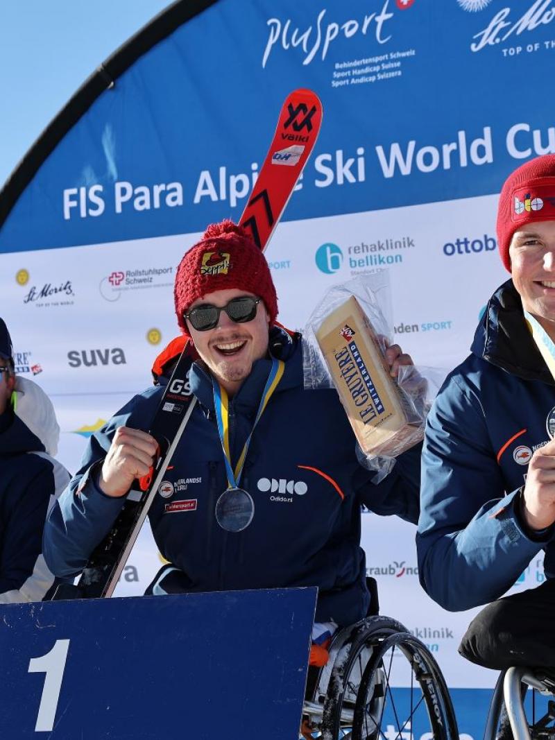 Three male sit skiers pose for a photo on the podium.