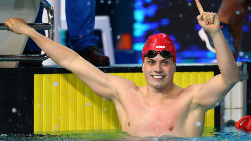 a male Para swimmer celebrates his win in the pool