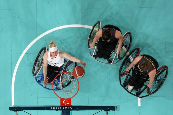 An overhead shot of Robyn Love, a female wheelchair basketball athlete, scoring during a game