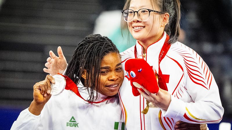 Two female athletes hugging with their medals
