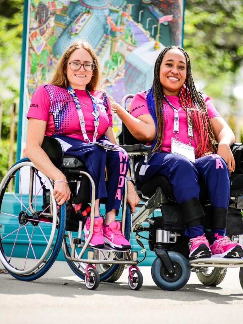 Two female athletes wearing a pink T-shirt pose for a photo