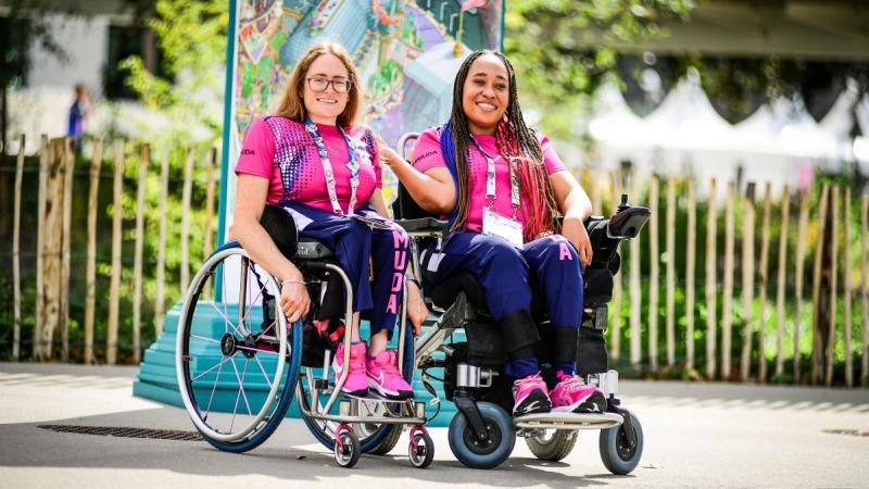 Two female athletes wearing a pink T-shirt pose for a photo