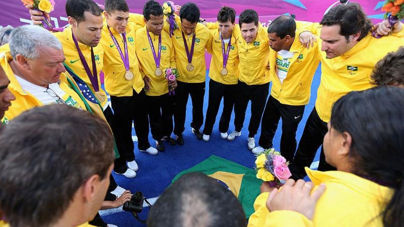 Blind football players and staff form a circle after receiving their gold medals at the London 2012 Games.