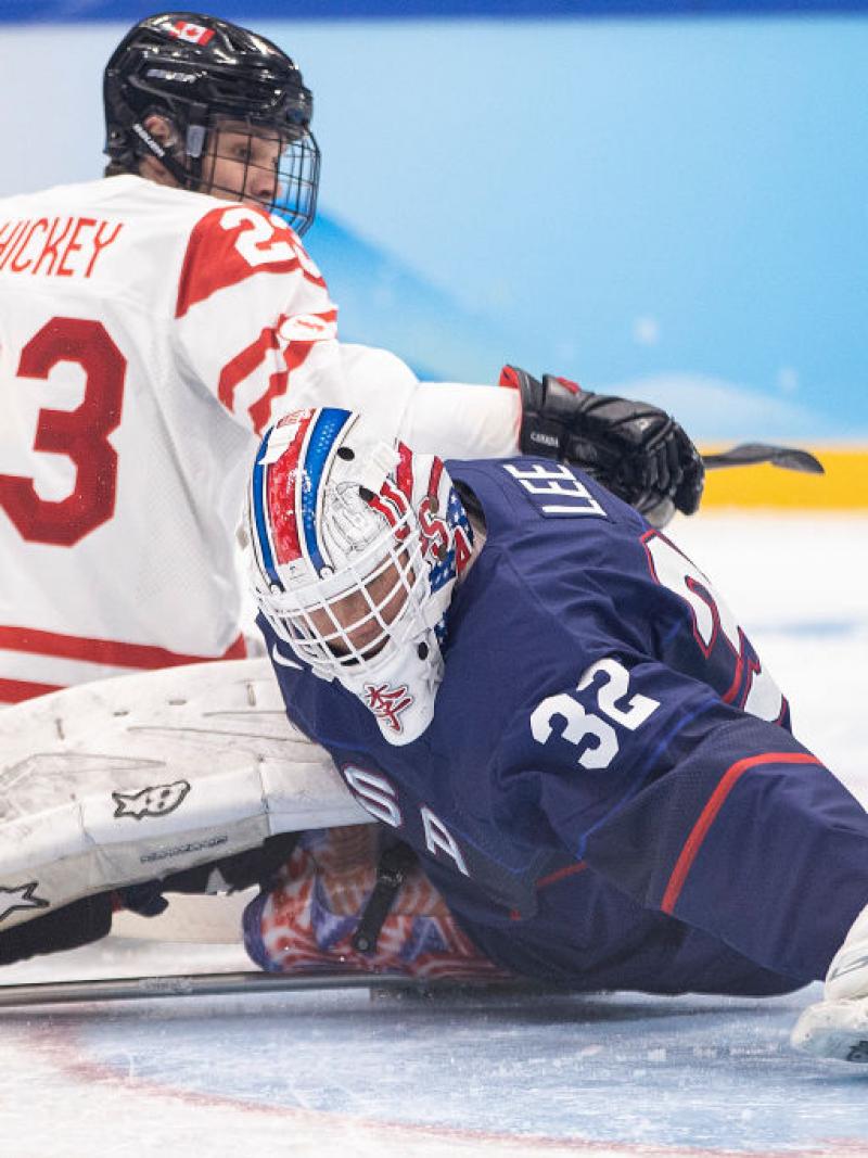 A Para ice hockey goaltender making a save in front of an opponent