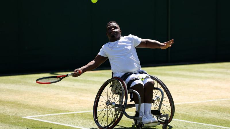 Wheelchair tennis player Donald Ramphabi prepares to hit the tennis ball