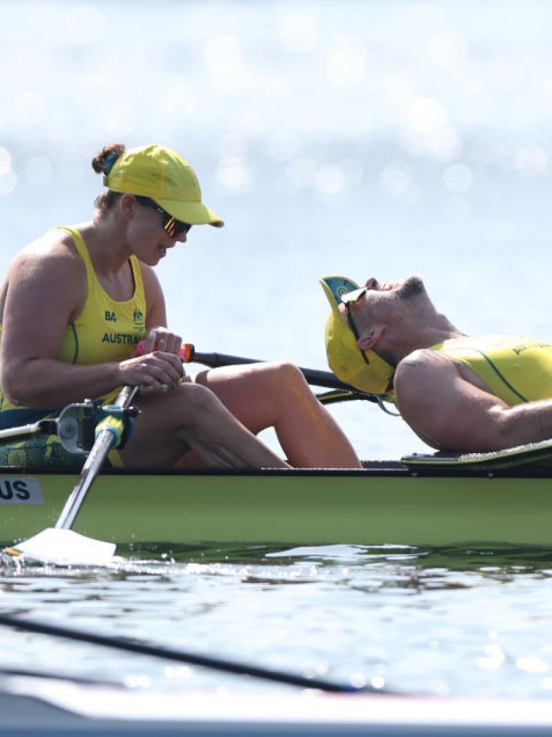 Two Australian rowers, dressed in yellow, look exhausted after winning gold in Paris