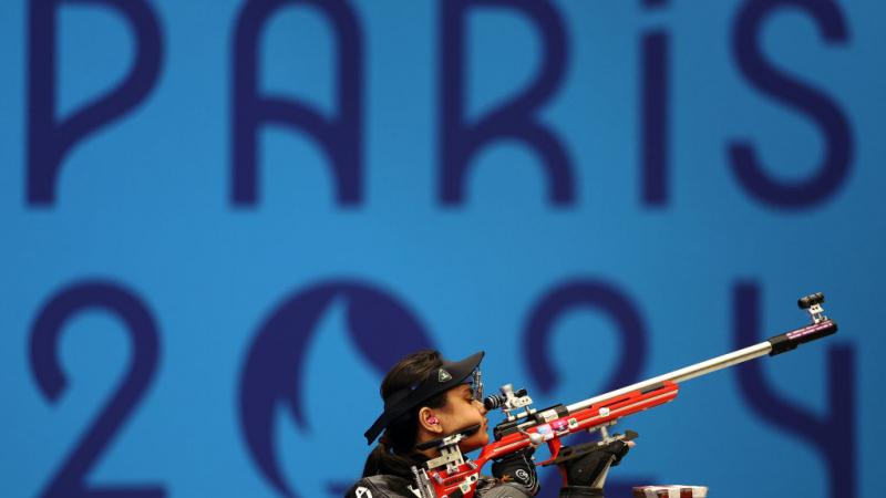 A female shooter with a rifle in a competition at Paris 2024