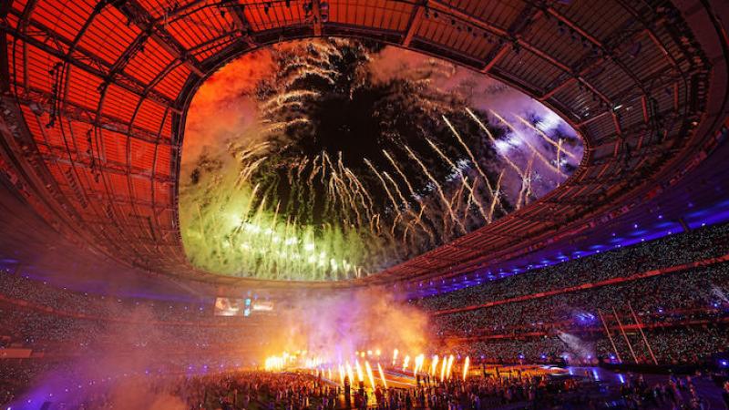 Fireworks slight up the centre and roof of a large stadium