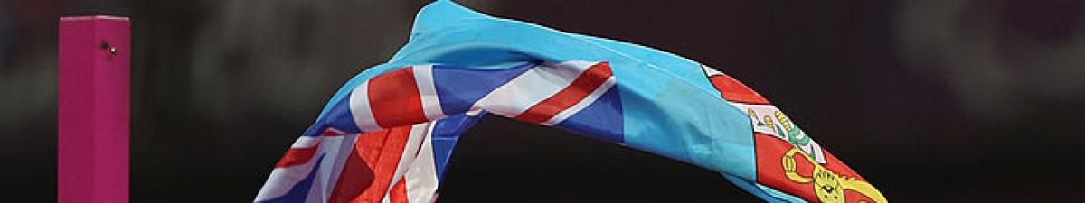 a male Para high jumper with a flag