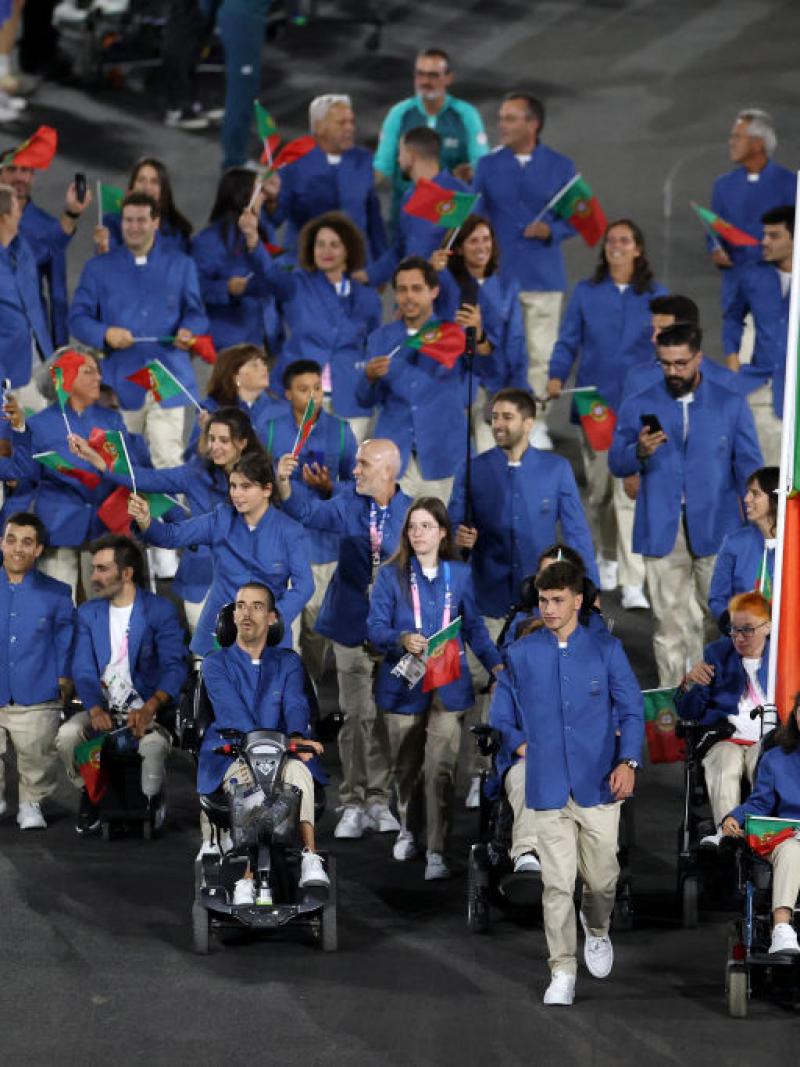 About 30 athletes take part in the parade of nations at the Paris 2024 Paralympic Opening Ceremony. They are all wearing a blue jacket and carries small flags of Portugal