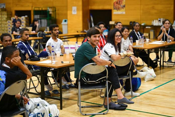 About 13 people are sitting and listening to a presentation.