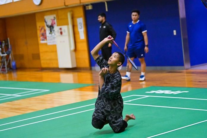 A male Para badminton player is shooting with a racquet