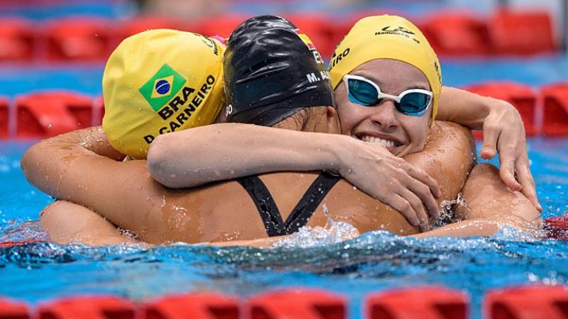 Debora and Beatriz Borges Carneiro hug in the pool