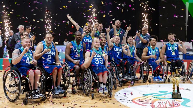 About 20 wheelchair basketball players and officials celebrate after winning the gold medal.