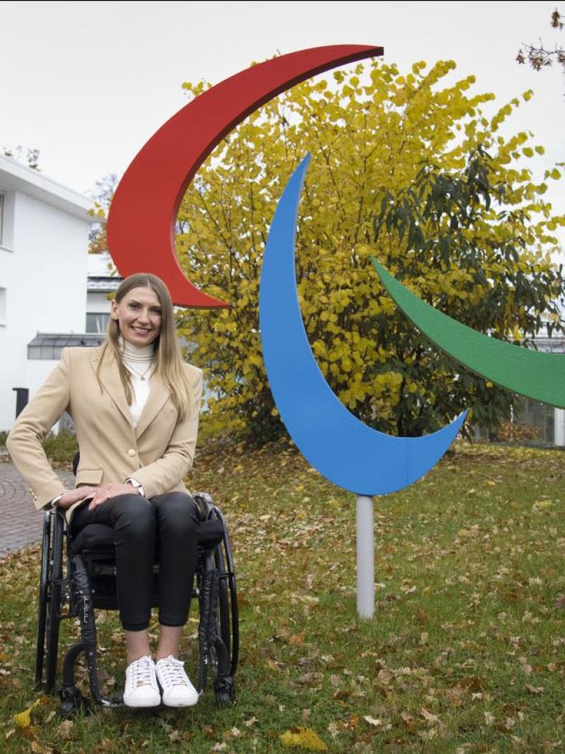 Vladyslava Kravchenko poses for a photograph next to the Paralympic symbol in front of the IPC headquarters in Bonn, Germany