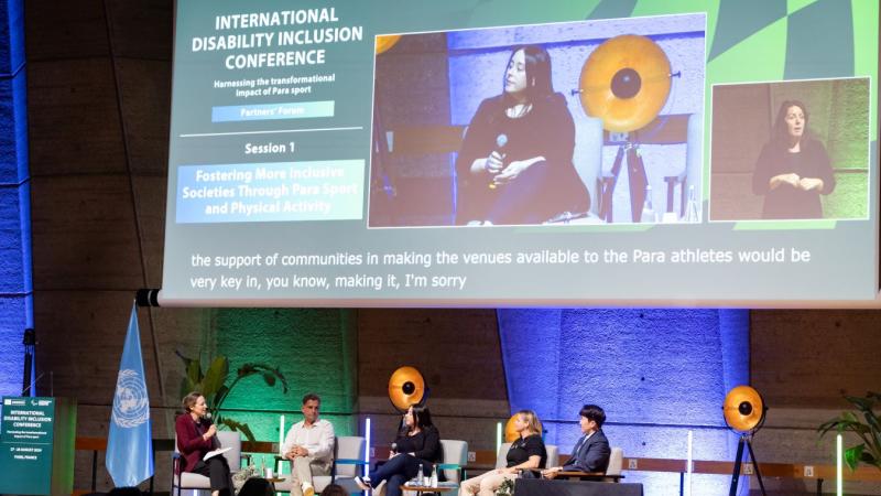 Five persons speaking to the public in a conference